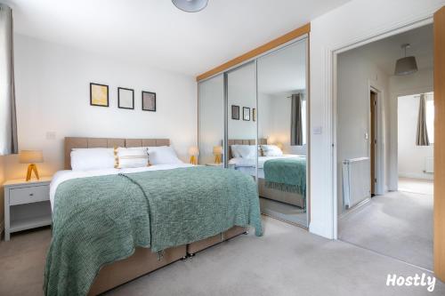a bedroom with two beds and a large mirror at Albatross House - Comfy Home with Parking in Slough