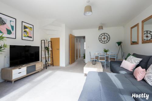 a living room with a couch and a flat screen tv at Albatross House - Comfy Home with Parking in Slough