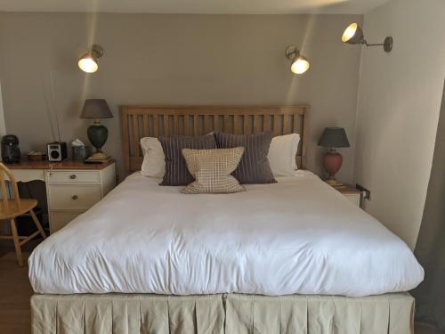 a bedroom with a large white bed with two pillows at Elderbrook House in Avebury