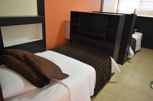 a bedroom with a bed with a television on it at Hotel La Laguna Galapagos in Puerto Villamil