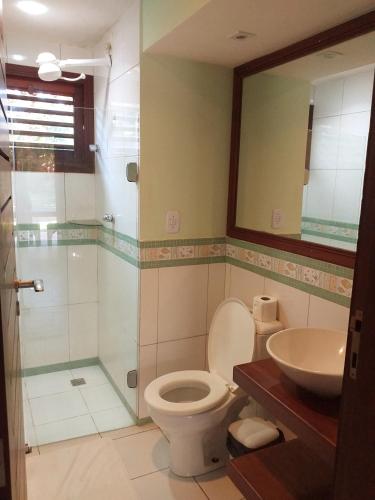a bathroom with a toilet and a shower and a sink at Paraiso Tropical - Casa 7 in Pipa