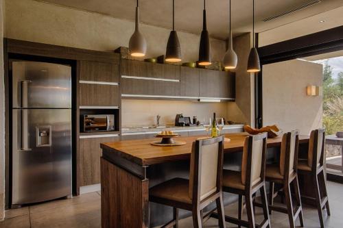 a kitchen with a wooden table and a refrigerator at The Vines Resort & Spa in Los Sauces