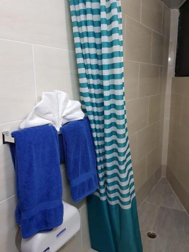 a bathroom with blue towels on top of a toilet at Hotel Plaza Europa in Sosúa
