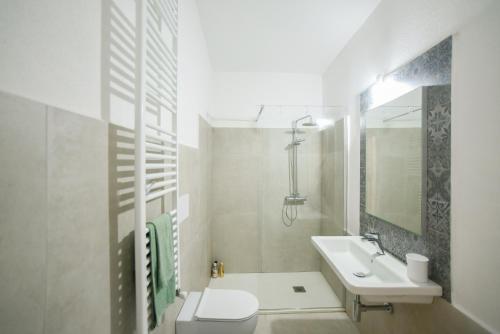uma casa de banho branca com um lavatório e um WC em Tatta & Nanna Apartment em Oliena