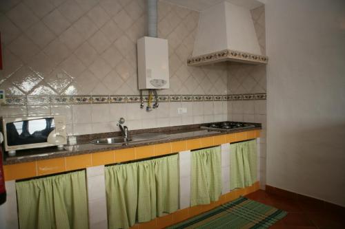 a kitchen with a sink and a stove at Apartamentos Canal da Agua in Odeceixe