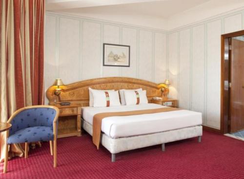 une chambre d'hôtel avec un lit et une chaise dans l'établissement Gloria Inn Najran, à Najran