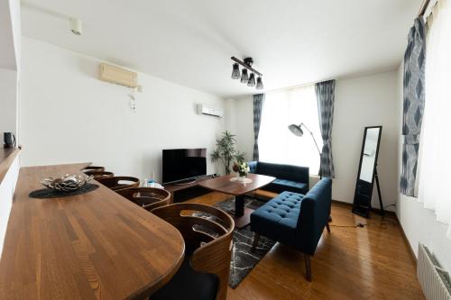 a living room with a dining room table and chairs at Hongo Street House - Vacation STAY 8609 in Sapporo