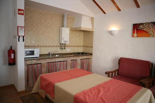 a bedroom with a bed and a kitchen with a sink at Apartamentos Canal da Agua in Odeceixe