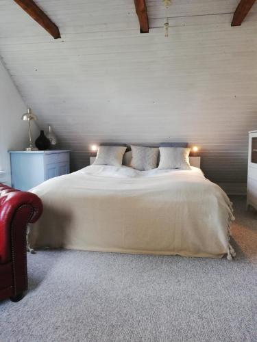 a bedroom with a large white bed with two pillows at Tankefuld Living's Horsefarm in Svendborg