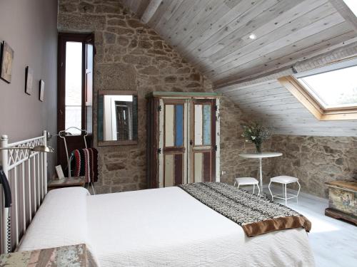a bedroom with a large bed in a stone wall at Apartamentos Teixoeira in Artes
