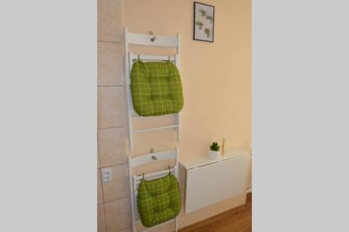 a shelf in a bathroom with green towels at 9th floor Amazing View Central Studio Apartment in Vilnius