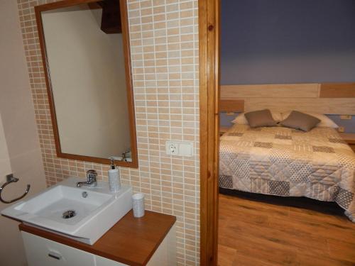 a bathroom with a sink and a bed at Masia Lledó de Trascastell in Balsareny