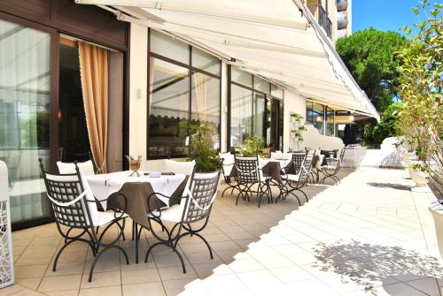 a group of tables and chairs on a patio at Palace Hotel Regina in Bibione
