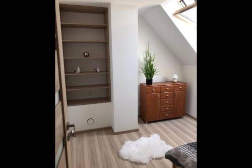 a room with a closet and a dresser with a plant on it at Domek Polny czar in Pogorzelica