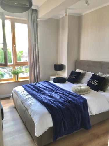 a bedroom with a large bed with a blue blanket at Marina Blue-Apartament przy promenadzie in Ełk