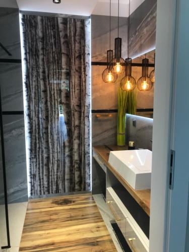 une salle de bains avec un lavabo et un miroir dans l'établissement Marina Blue-Apartament przy promenadzie, à Ełk