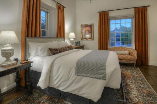 a bedroom with a large bed and a chair at Armory Park Inn in Tucson