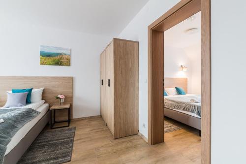 a bedroom with two beds and a mirror at Willa Domiwera in Polańczyk