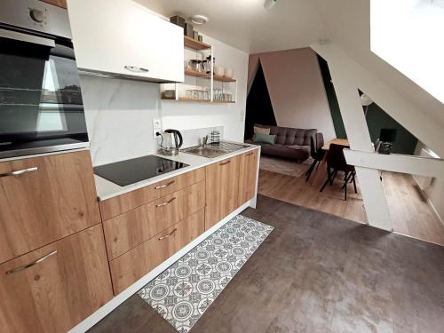 a kitchen with wooden cabinets and a living room at Les Hauts des Caps in Boulogne-sur-Mer