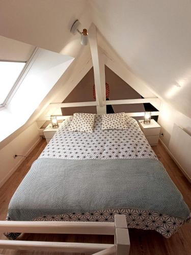 une chambre avec un grand lit dans un grenier dans l'établissement Les Hauts des Caps, à Boulogne-sur-Mer