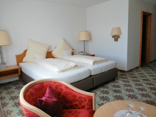 a hotel room with a bed and a chair and a table at Landhotel Reckenberg in Stegen