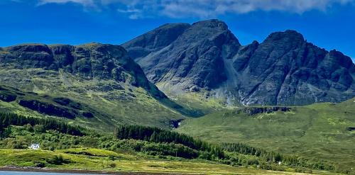 a mountain range with a house in front of it at The Lodge Dunrowan in Kyle of Lochalsh