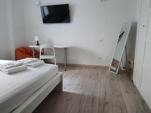 Zimmer mit einem Bett, einem Tisch und einem TV in der Unterkunft Isabella d'Aragona Guest House in Barletta