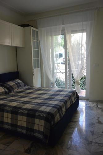 - une chambre avec un lit et une porte coulissante en verre dans l'établissement Mare Foce e Centro, à Sanremo