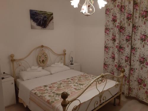 a bedroom with a bed with white sheets and flowers at Villa Claudia in Fažana