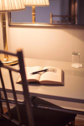 an open book sitting on a table with a chair at Grand Hotell Hörnan in Uppsala