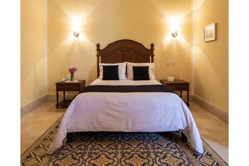 a bedroom with a large bed with two end tables at Casa Tavera in Mérida