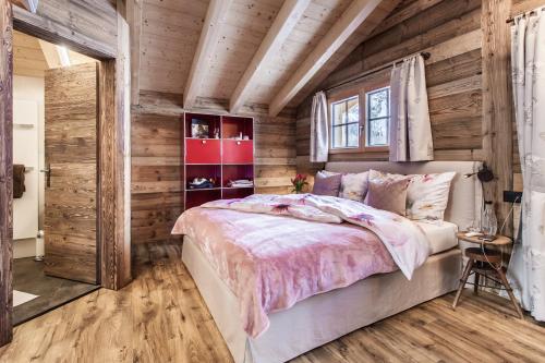 a bedroom with wooden walls and a large bed at Mountain Chalet 4 You in Zermatt