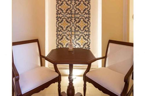 a table and two chairs with a table and a wall at Casa Tavera- Adults Only in Mérida