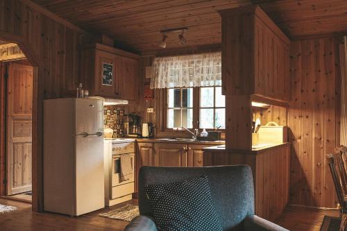 Sjoaasen Hytte في Tuddal: مطبخ بجدران خشبية وثلاجة