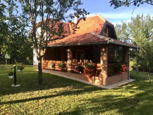 a small house with a porch in a yard at Seosko domaćinstvo Bondžulić in Užice