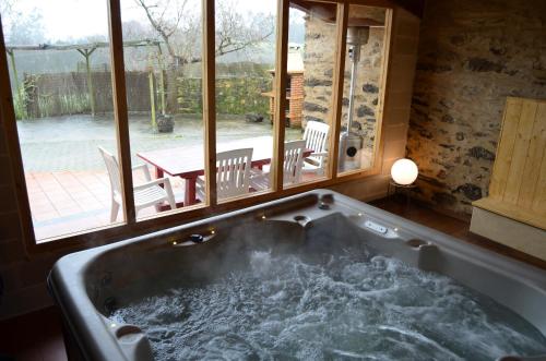 bañera grande en una habitación con ventana en Casa Fonte do Barro SPA opcional, en Santiago de Compostela