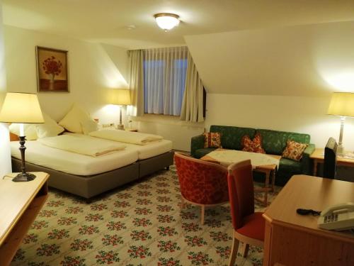 a hotel room with a bed and a couch at Landhotel Reckenberg in Stegen