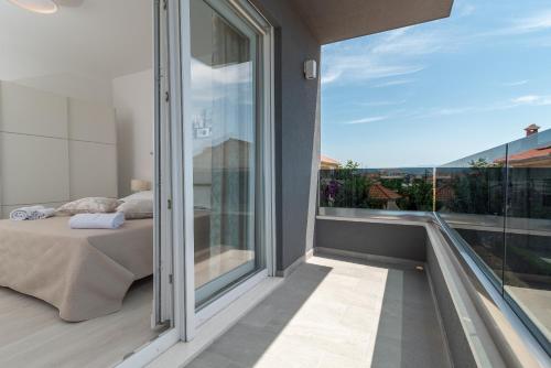 ein Schlafzimmer mit einem Bett und einem großen Glasfenster in der Unterkunft Villa Dalmata in Trogir