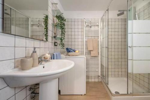 ein weißes Bad mit einem Waschbecken und einer Dusche in der Unterkunft Capitana Rooms in Costa degli Angeli
