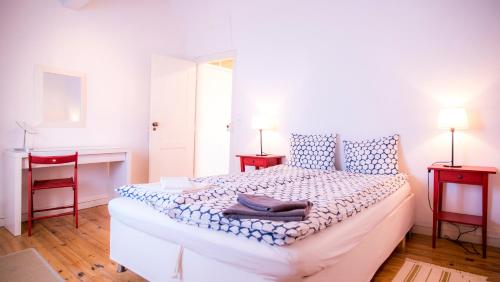 a bedroom with a white bed with two red chairs at Apartamento Joaquim Tello in Lagos