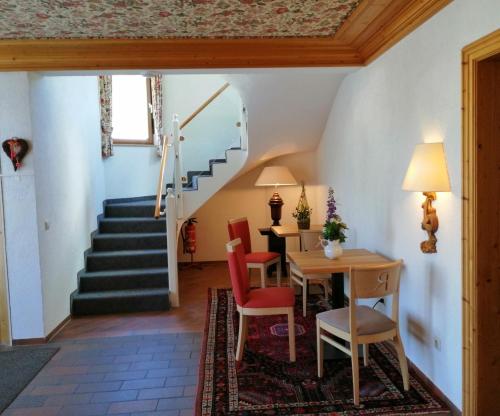 a room with a table and chairs and a staircase at Landhotel Reckenberg in Stegen