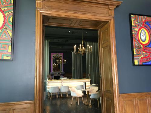 a dining room with a table and chairs and a mirror at Hôtel de France in Auch