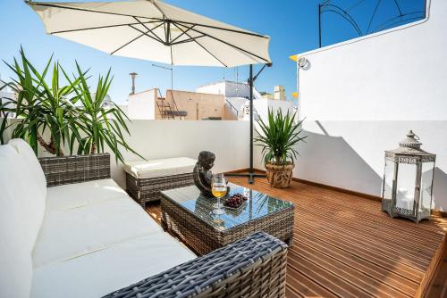patio con divano, tavolo e ombrellone di CASA DA AVO by Ammonite&Co a Olhão