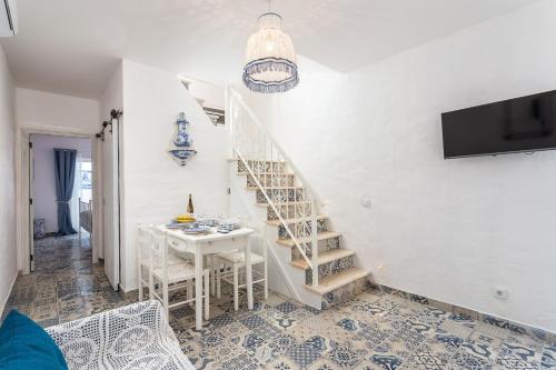 soggiorno con scala e tavolo di CASA DA AVO by Ammonite&Co a Olhão