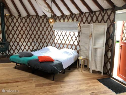 ein Schlafzimmer mit einem Bett in einer Jurte in der Unterkunft Authentieke Yurt voor 6 personen in Reutum