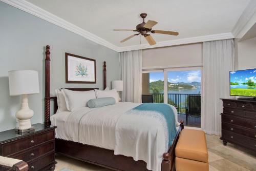 a bedroom with a bed and a flat screen tv at Great Bay Condominiums located at The Ritz-Carlton Club, St Thomas in St Thomas