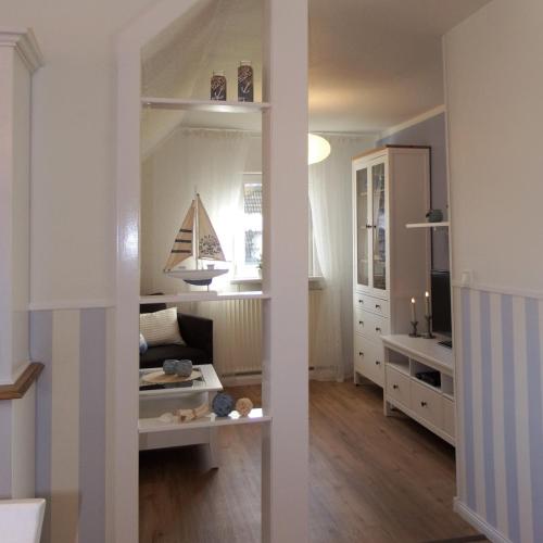 a living room with a large mirror in a room at Ferienwohnung Seestern - Alte Schmiede Neugarmssiel in Wangerland