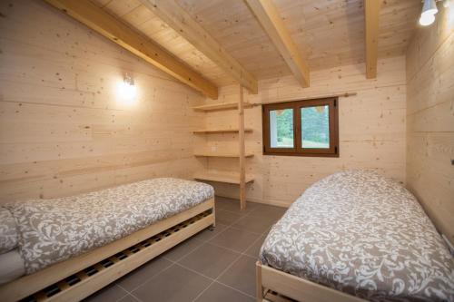 um chalé de madeira com duas camas num quarto em gîtes à la ferme dela le var em Guillaumes