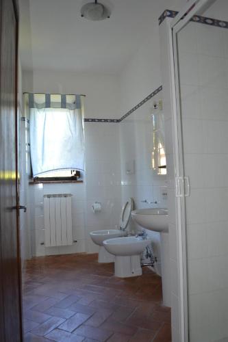 a bathroom with two sinks and a toilet and a window at Agriturismo La Creta in Montepulciano