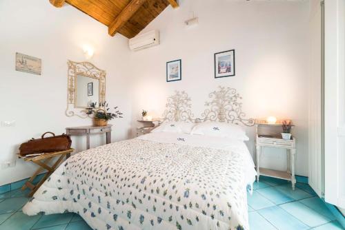 a white bedroom with a bed and a mirror at B&B Gattacicova in Cava deʼ Tirreni
